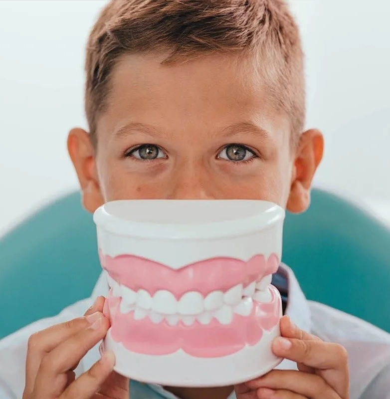 niño mostrando una dentadura en clinica dental malaga
